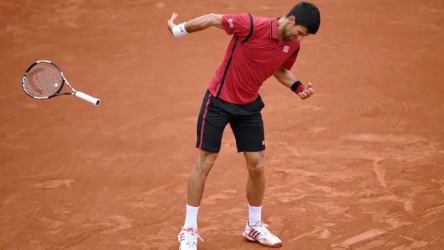 Novak Djokovic throws his racket