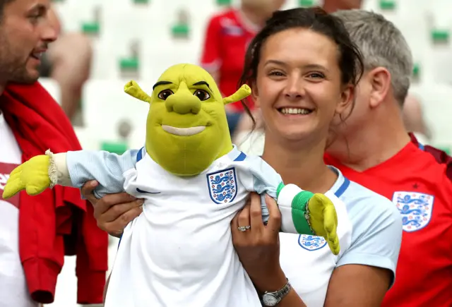 An England fan with a Shrek toy