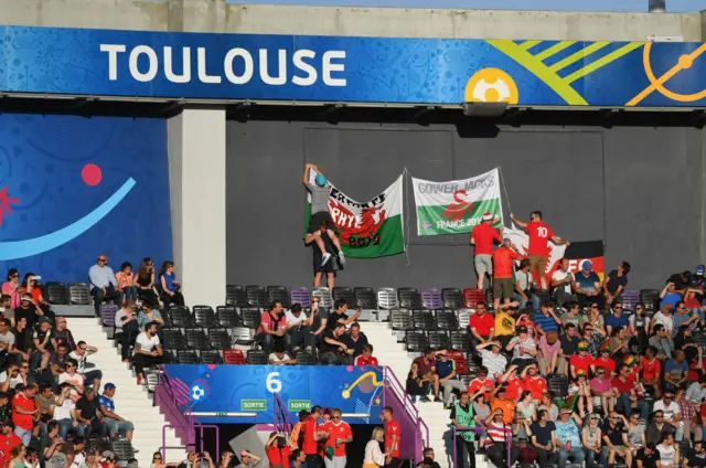 Wales fans pin up a flag