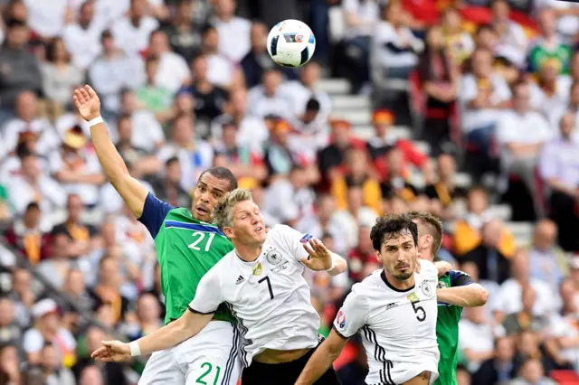 Josh Magennis and Germany's midfielder Bastian Schweinsteiger