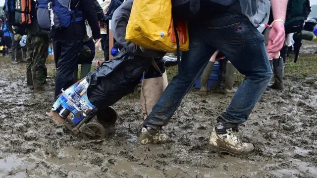 Man pulling a cart through mud