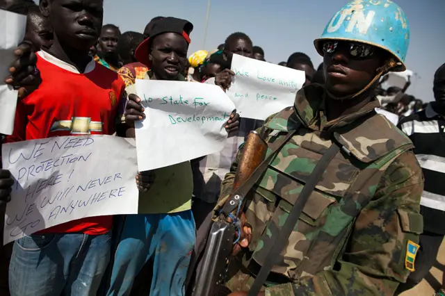 Displaced people residing in the United Nations Protection of Civilians (PoC) site in Malakal, demonstrate against the violence in the camp in front UN police officers and a UN delegation on February 26, 2016