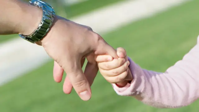 Adult holding a childs hand