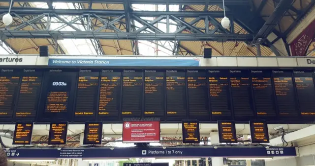 Signs showing delayed trains at Victoria Station, London