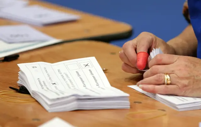 A counter leafs through ballots