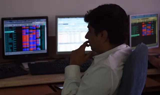 A stock dealer watches share prices on his screen at a brokerage house in Mumbai