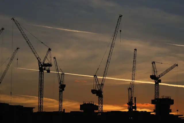 The sun sets behind cranes at the re development site at Battersea Power Station