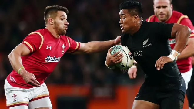 Julian Savea is tackled by Rhys Webb