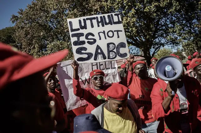 Members and supporters of the Economic Freedom Fighters (EFF) carry a placard reading 'Luthuli is not SABC' (Luthuli house is the headquarters of the SABC) as they sing and dance before marching to the South African Broadcasting Corporation (SABC) headquartes to protest the banning of their election campaign advert on April 29, 2014 in Johannesburg