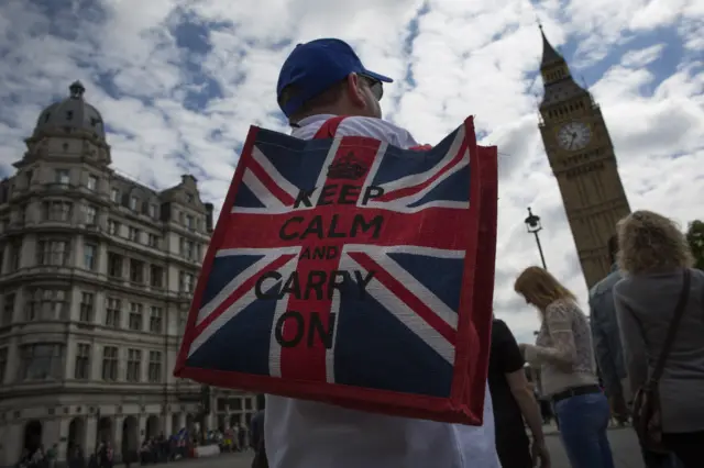 A man carries a bag bearing a Union flag design and the slogan: Keep calm and carry on