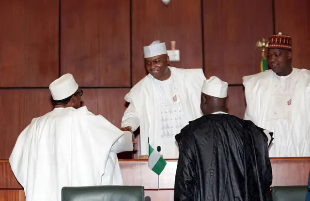 Nigerian President Muhammadu Buhari (L) shakes hand with the Senate President Olusola Saraki, (C) as Speaker House of Representative Yakubu Dogara looks after submiting his budget for 2016 in Abuja, on December 22, 2015