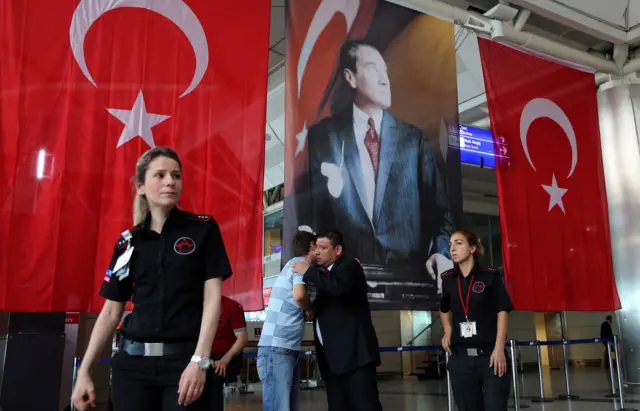 Turkish flags flank a picture of Ataturk in the airport