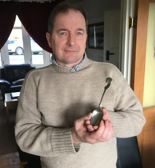 Rod Cooper holding a spoon which deflected a bullet