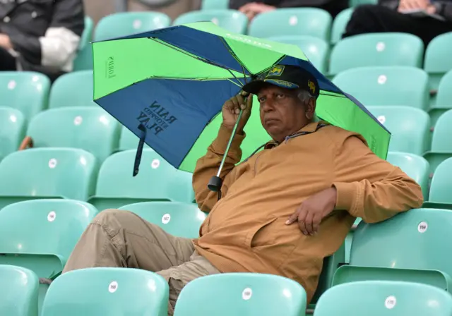 A Sri Lanka fan shelters from the rain