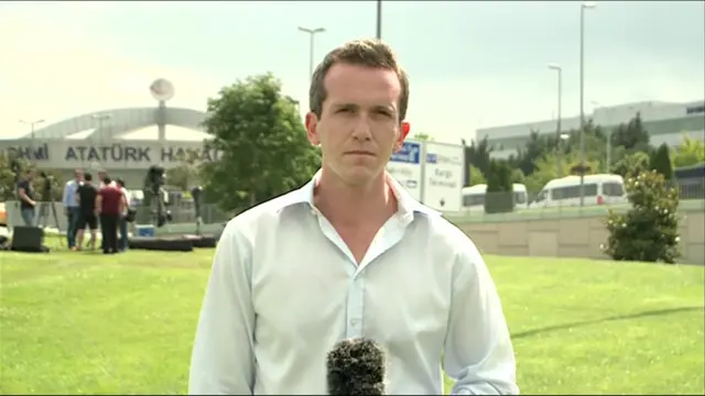 Mark Lowen with a microphone outside the airport