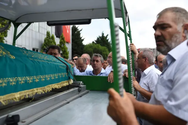 mourners around hearse