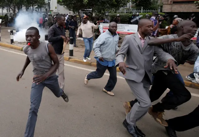 Protesters running from tear gas