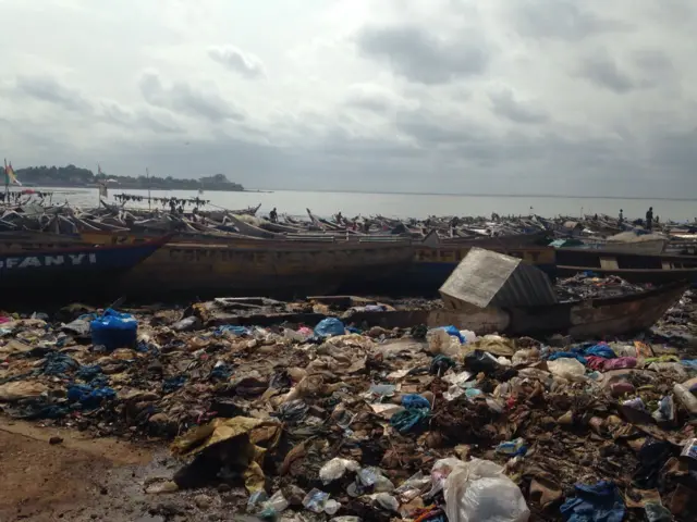 Boats at the port with rubbish strewn all around