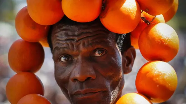 Man with a ring of oranges around his head