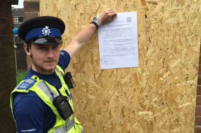 Police Community Support Officer puts eviction notice up