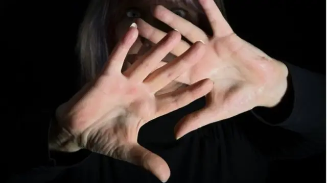 Hands held up in front of woman