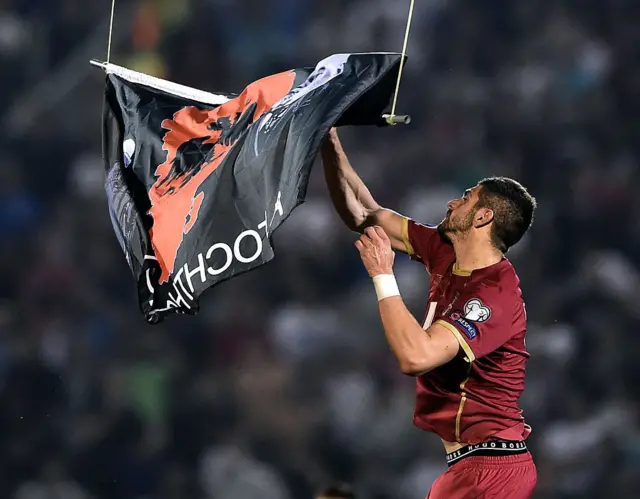 Albania players pulls a message from a drone