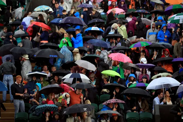 Fans hide from the rain