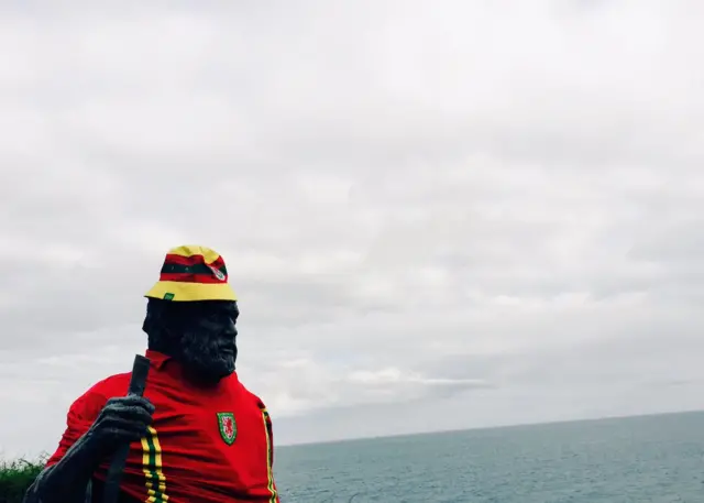 Saint Crannog's statue in a Welsh shirt and bucket hat