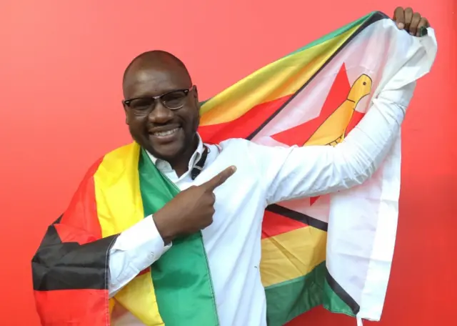 In this Tuesday May 3, 2016 file photo, shows Evans Mawarire, a young pastor, posing with a Zimbabwean flag in Harare, Zimbabwe. Zimbabwe police have charged Mawarire on Tuesday July 12, 2016, with inciting violence and disturbing the peace.