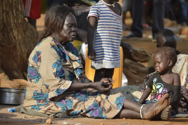 In this Tuesday July 12, 2016 photo, a woman sits with her child near a church in Juba, South Sudan.