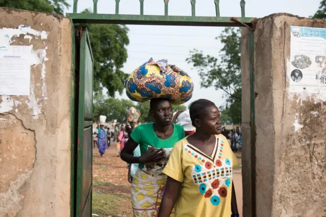 Families leave Saint Joseph's church compound in Juba, after receiving small food ratios by the Red cross and other NGO"s on July 12, 2016 in Juba.