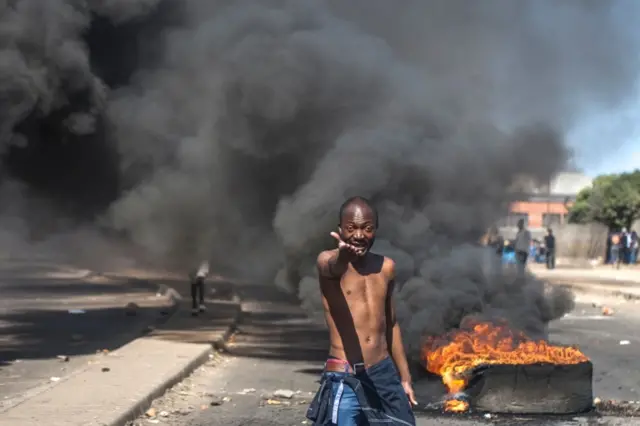 This file photo taken on July 06, 2016 shows a protester shouting anti-Mugabe slogans in front of burning tyres during a demonstration on July 6 2016, in Makokoba, Bulawayo Zimbabw