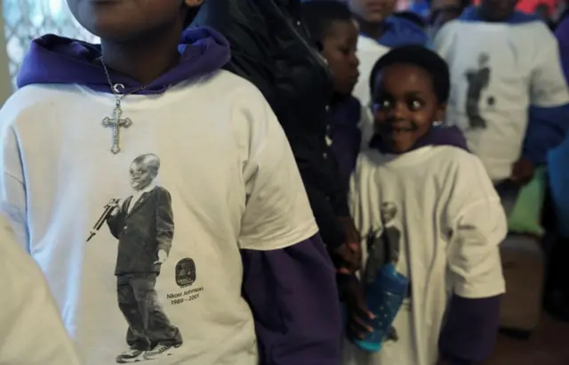 A child wears a cross over a top featuring the image of the late Nkosi Johnson, one of the youngest victims of the HIV epidemic and died in 2001 from the disease, during the launch of the 5-Day countdown ahead of the AIDS2016 International Conference, at the orphanage Nkosi"s Haven, which was named after Johnson, in Johannesburg, South Africa July 13, 2016