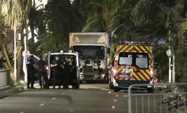 Police officers stand guard near the truck after it crashed into the crowd during the Bastille Day celebrations in Nice, France, 14 July 2016.