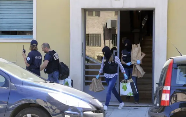 French investigating police carry evidence bags after conducting a search at the apartment believed to have been the residence of the lorry driver