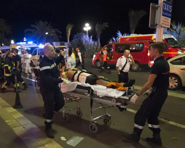 Emergency workers remove injured people from the scene in Nice