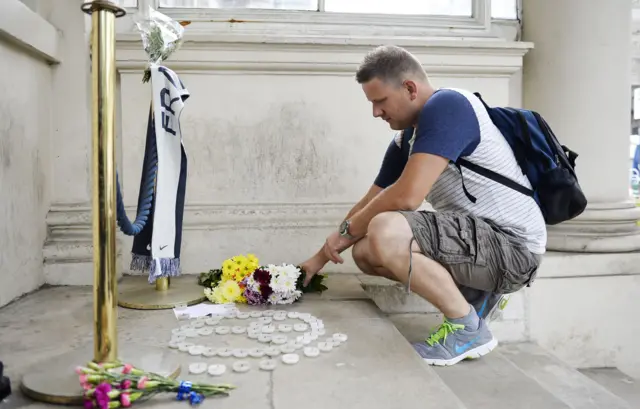 A man lays flowers outside the French Embassy in London