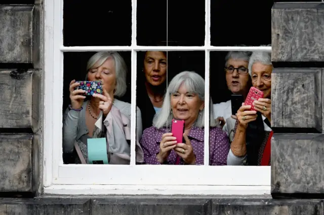 Members of the public watch the meeting between the two leaders