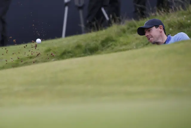 Rory McIlroy takes a shot from a bunker