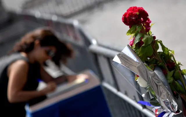 A woman signs the book of condolences in front of the French embassy in Rome on July 15