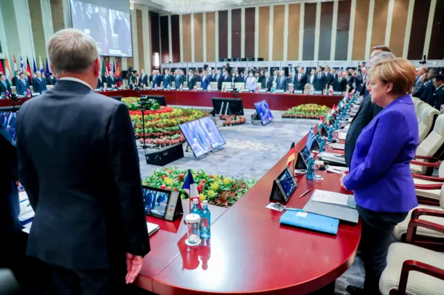 Attendees, including German Chancellor Angela Merkel (right) and French Foreign Minister Jean-Marc Ayrault (left), observe a moment of silence for the victims of the attack in Nice, at the beginning of the Asia-Europe Meeting (ASEM) Summit in Ulan Bator, Mongolia.