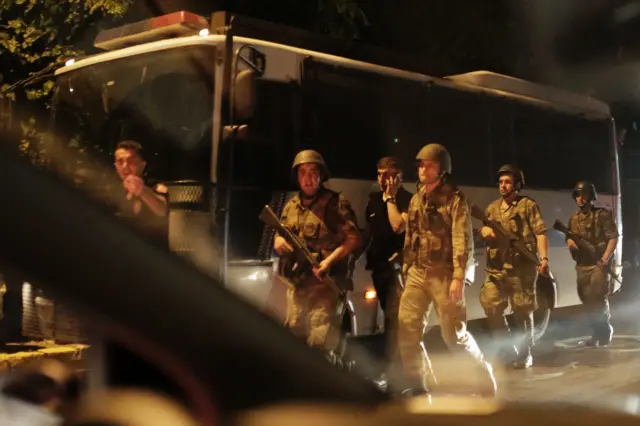 Turkish security officers detain Turkish police officers (in black) on 15 July 2016 in Istanbul, during a security shutdown of the Bosphorus Bridge.