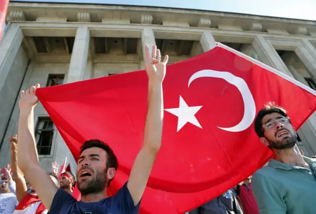 Turkish citizens wave their national flag and shout slogans, as they protest against the military coup outside Turkey's parliament near the Turkish military headquarters in Ankara