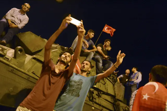 Supporters of Tukish President Tayyip Erdogan take a sefie with an armored vehicle in front of Ataturk Airport in Istanbu