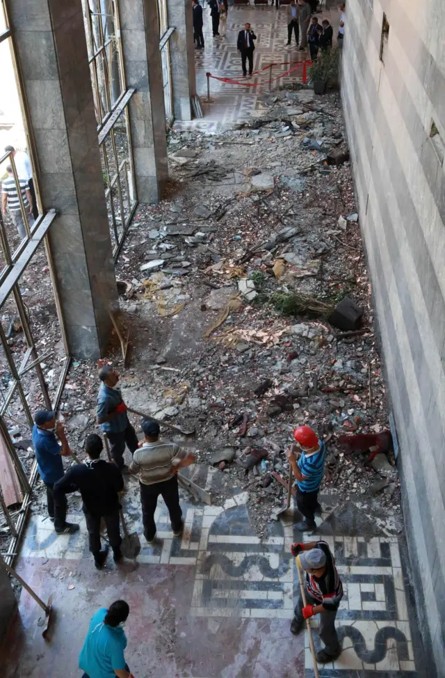 Workers inspect and clear debris