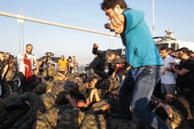 People jump on soldiers involved in the coup attempt who have surrendered on the Bosphorus bridge