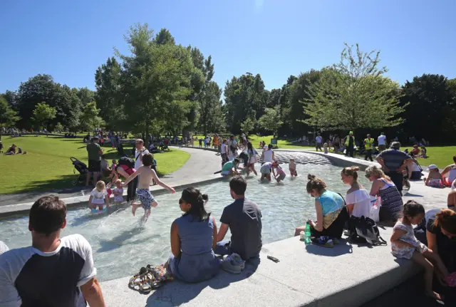 People enjoying the sunshine at the Diana, Princess of Wales Memorial Fountain in Hyde Park, London on Monday