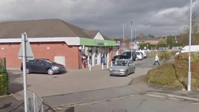 Convenience store with cars driving by it