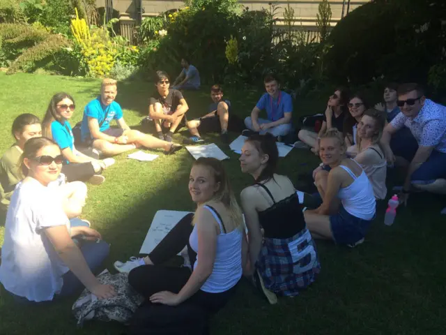 Young people sit in the sun