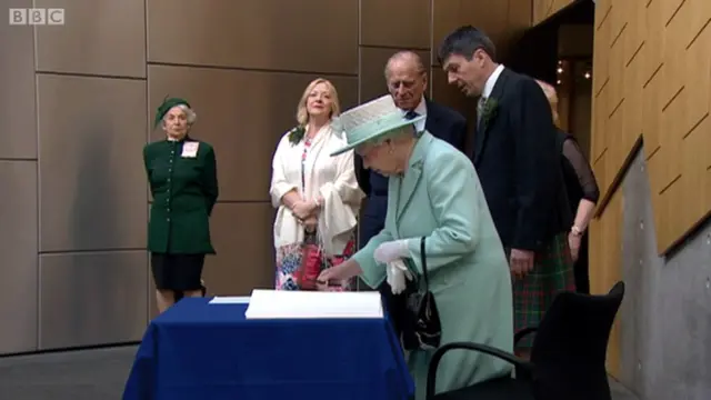 Queen signs visitors' book